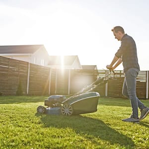 Man mows the lawn on a sunny day