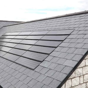 A black tiled roof with solar shingles installed