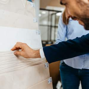 An elegant man selecting bathroom tiles for his home