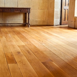 Closeup of wide plank, golden yellow wood floor with console table