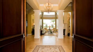 The hallway of a mansion with travertine tiles laid