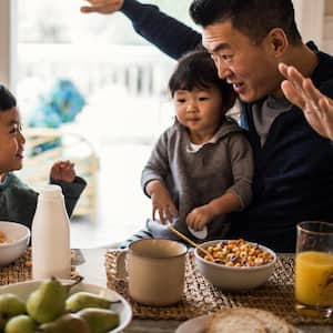 A father and his children having breakfast on the kitchen table