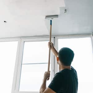 A man paints a ceiling