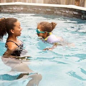 Older sister teaching her little sister how to swim