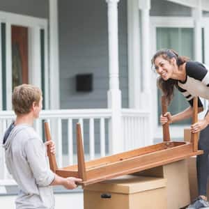 Couple moving furniture into new home