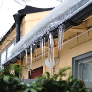 Ice gutters melting from a house roof