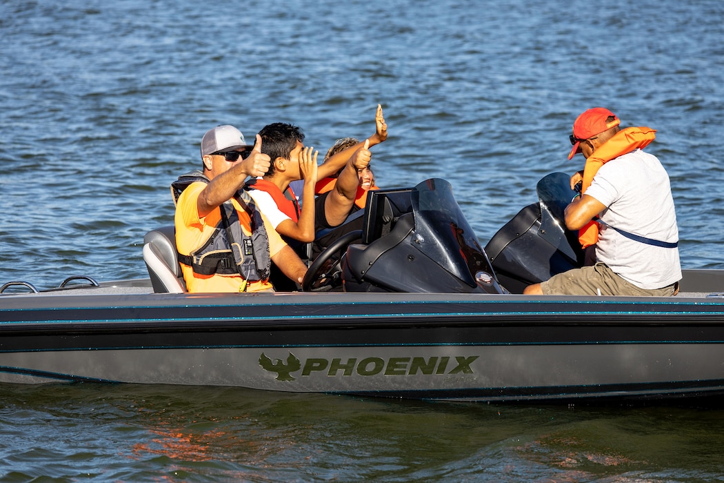 people waving from a boat on a lake