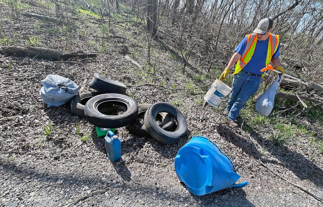 Person picks up trash in woods