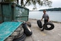 Park Ranger Dylan Norton carries tires collected from the shoreline of Lake Cumberland to a collection point at Waitsboro Recreation Area in Somerset, Kentucky, Sept. 25, 2021. As a member of the U.S. Army Corps of Engineers Nashville District staff at the lake, he helped organize the annual cleanup event and worked with partners and volunteers to pick up tons of trash. (USACE Photo by Lee Roberts