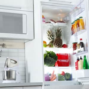 An open fridge in a stylish white kitchen