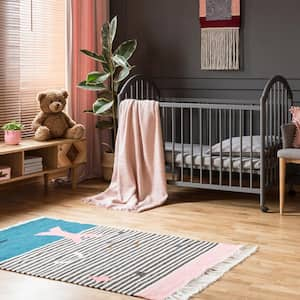 A child’s room with a baby crib with hardwood floors and a rug