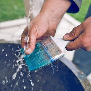 Man washing brush blue paint