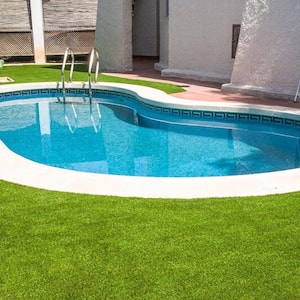 Artificial lawn around a swimming pool in a house’s backyard