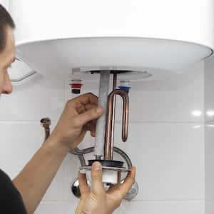 person repairs pipes of water heater