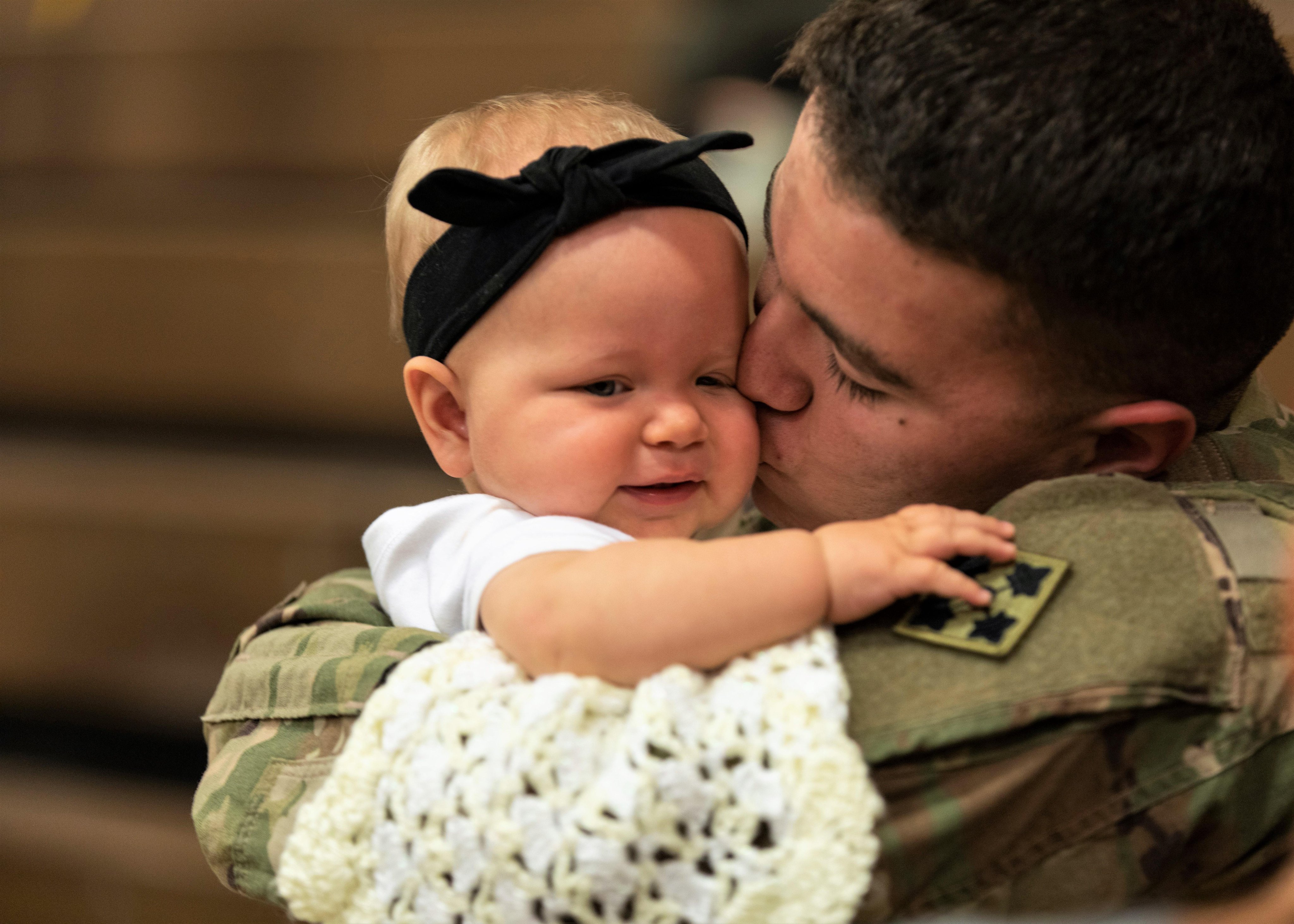 Spc. Dallas Ochoa, assigned to the 2nd Infantry Brigade Combat Team, 4th Infantry Division, reunites with his daughter, Kaylynn, following a homecoming ceremony at William Bill Reed Special Event Center, Fort Carson, Colorado. 