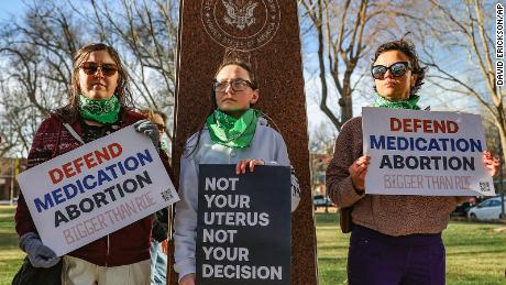 Three members of the Women&#39;s March group protest in support of access to abortion medication outside the Federal Courthouse on Wednesday, March 15, 2023 in Amarillo, Texas. 