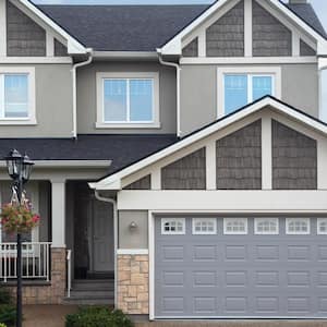 A two-story gray brick house with a garage