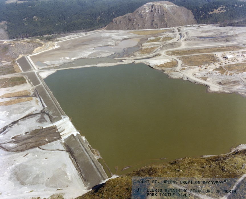 low dam holds back green water and sediment