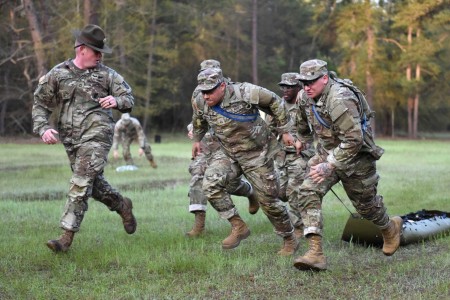 Infantry recruits with Bravo Company, 1st Battalion, 50th Infantry Regiment, compete in a medical-evacuation race during the First 100 Yards at Fort Benning, Georgia, March 30, 2023. The 90-minute event teaches new recruits how to quickly work together to accomplish the mission. 