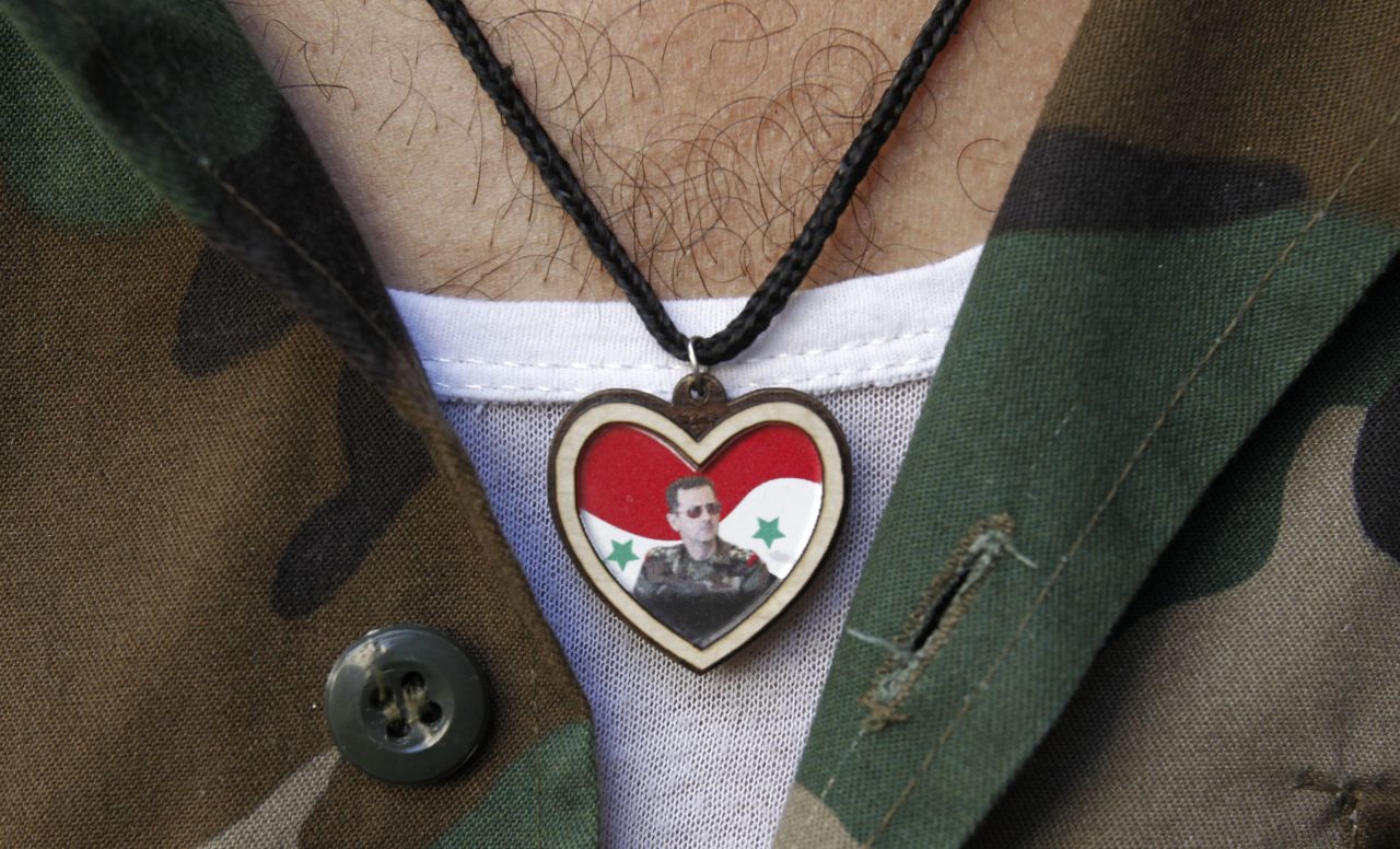 A soldier wears a picture of Syrian President Bashar al-Assad on his chest while at a market in old Damascus on September 8.