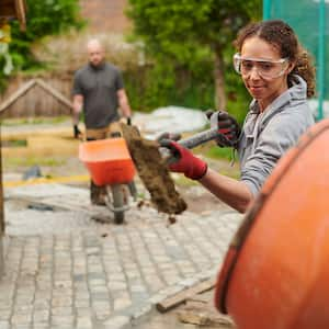 Woman mixing concrete in backyard