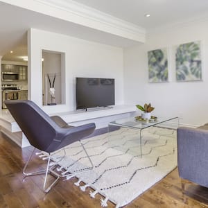 An open-space living room and kitchen located in a house’s basement