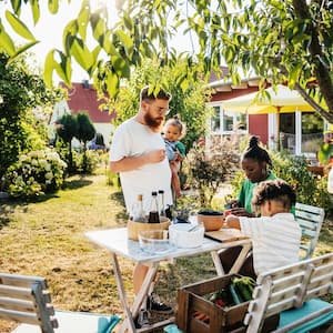 A family of four spending time around a table in their garden