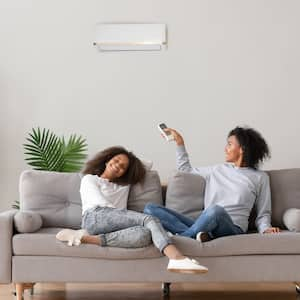 A woman and young girl relax on a couch enjoying the air conditioning