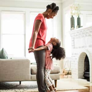 Girl standing on mothers feet