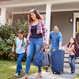 Family walks out of house with luggage