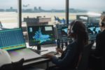 WORKERS SIT INSIDE AN AIR TRAFFIC CONTROL TOWER 