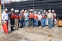 Heavy Mobile Equipment Mechanic Leader Robert Woods (center) and crew prepares for a safety meeting preceding the undocking of Revetment Mooring Barge 7401. (USACE photo by Brenda Beasley)