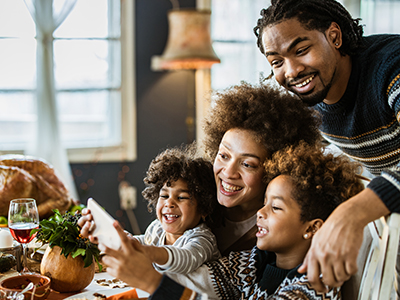 Black family laughing together at a Thanksgiving meal