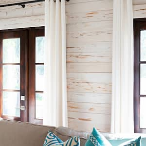 A living room with a sofa and shiplap wall