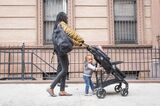 Young mother walking with infant daughter in the city