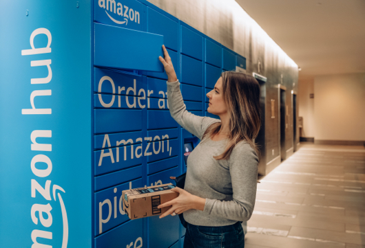 Woman opening a blue Amazon Hub Locker retrieving package.