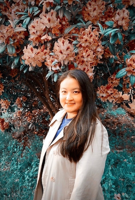 Photo of woman named Mary Hesser in front of a flowering tree at Spanaway Park, Spanaway, Washington state.