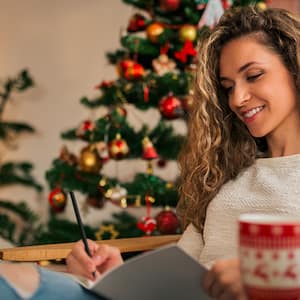 woman writing Christmas cards in living room