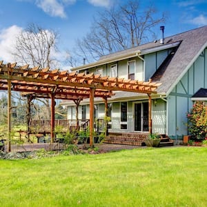 A beautiful farmhouse with an attached to the deck pergola