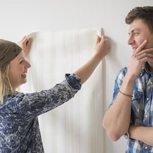 couple putting up wallpaper