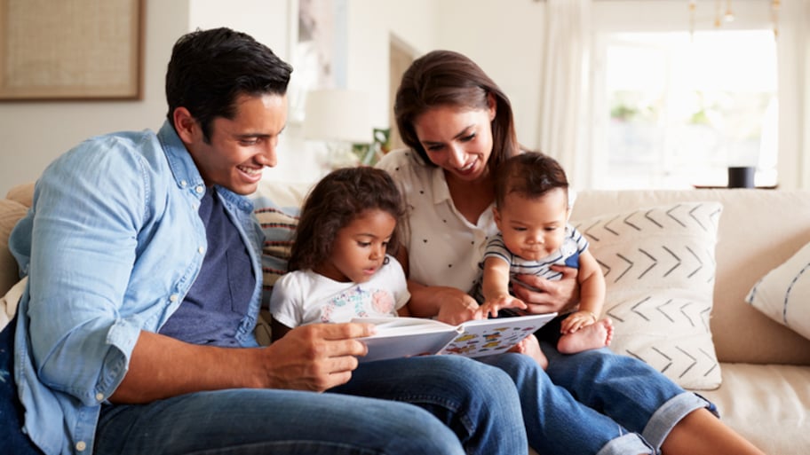 Young Hispanic family sitting on couch in living room