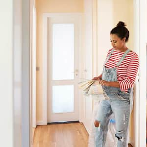 Woman in the hallway choosing paint color from color swatch