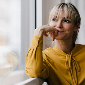 woman sitting at home looking out the window