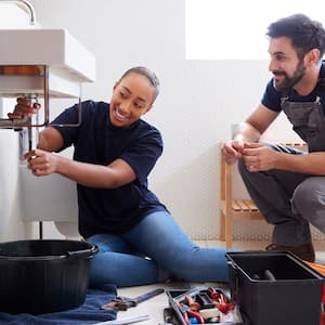 Plumbers fixing water pipes in a bathroom sink