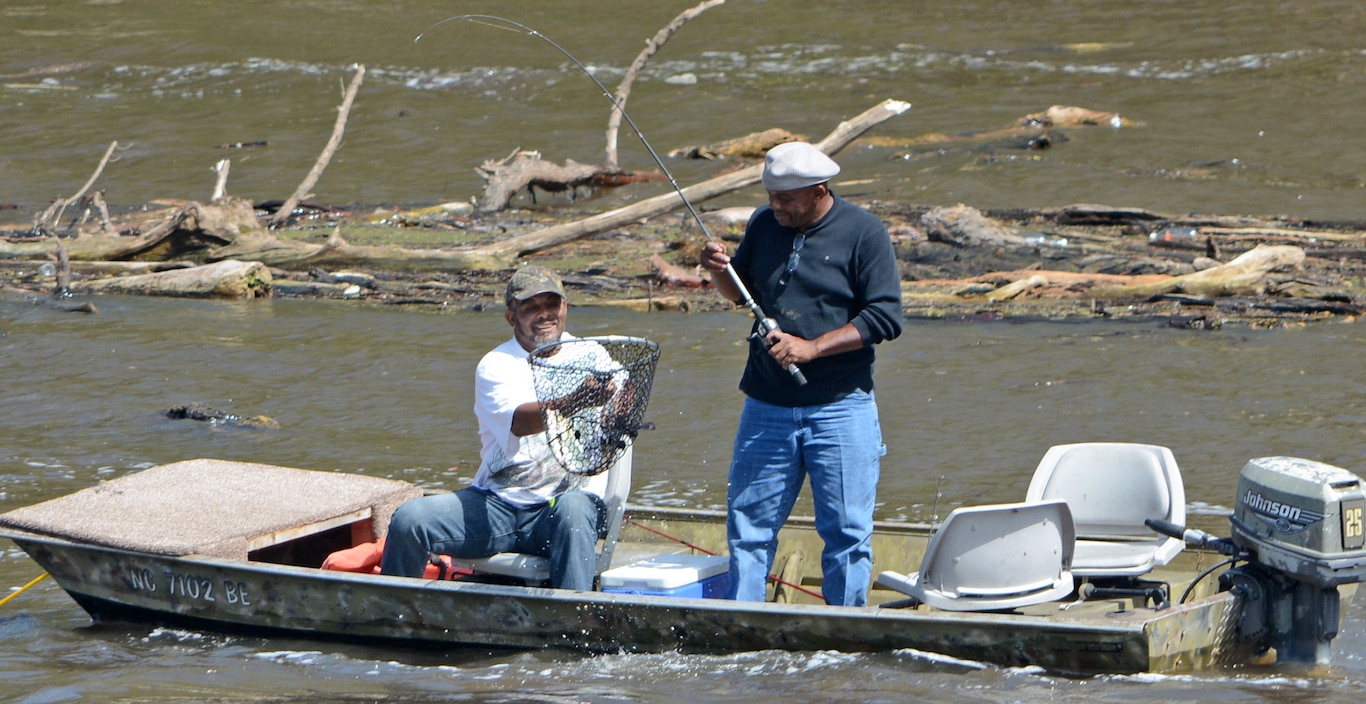 Two fisherman land an American shad fish at Lock and Dam 1.   