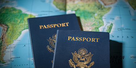 Two U.S. passports sitting on top of a world map.