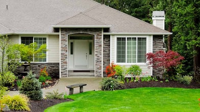 House with mulched flowerbeds and mature plants