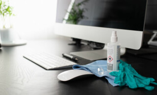 disinfectant and gloves near computer surfaces touched frequently