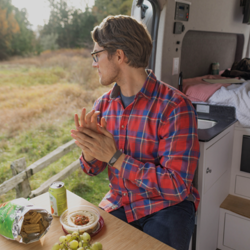 man eating at table in van