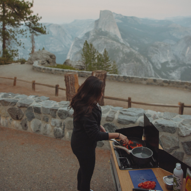 woman cooking on outdoor stove